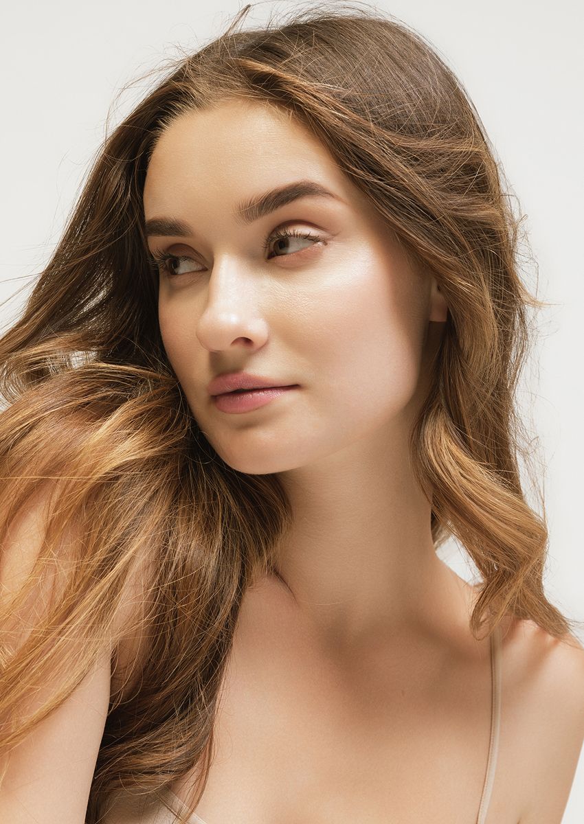 Woman with long hair looking thoughtfully to side.