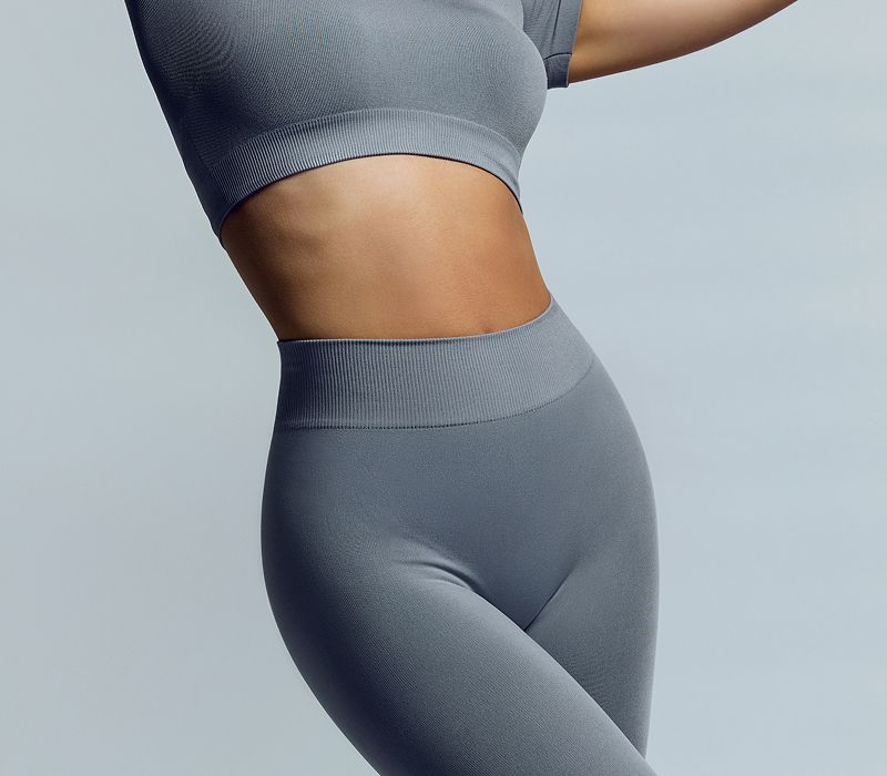 Model in gray athletic wear against a light background.